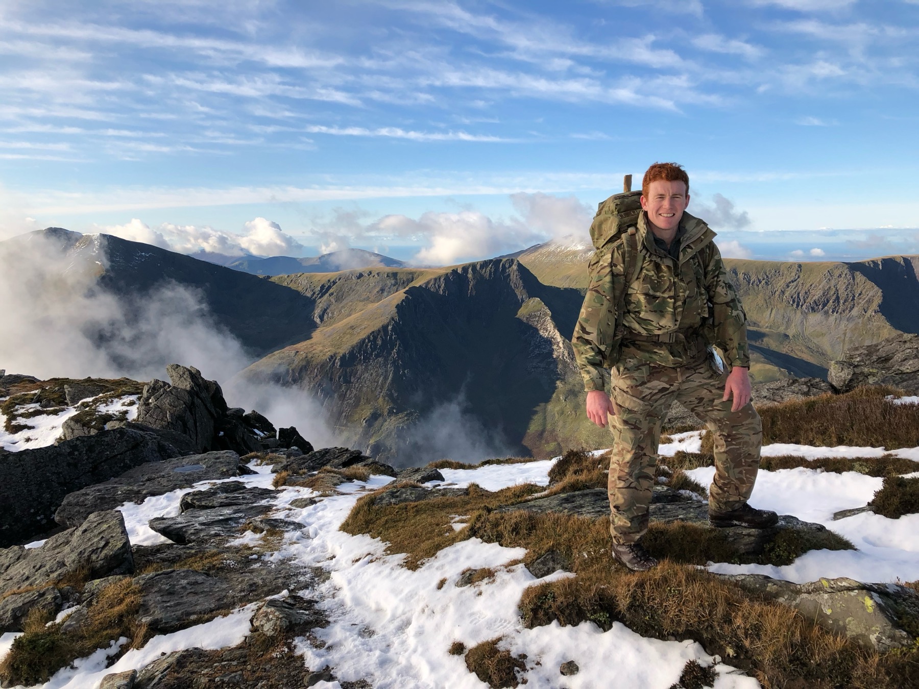 George on a snowy mountain summit in military kit